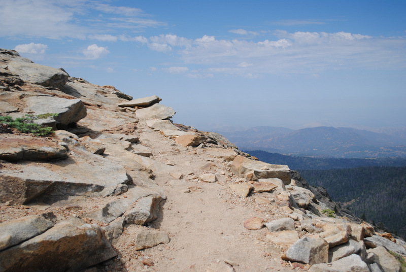 view from rock ledge into sky and valley below
